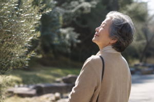 クリスマス会で祈りを受け、穏やかな表情で空を見上げる80代女性